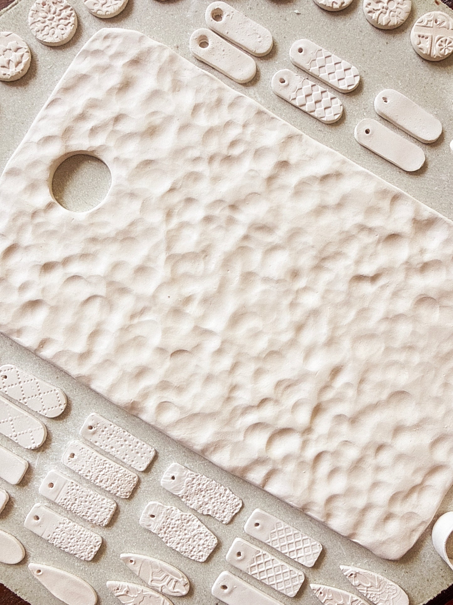 Close-up of a textured ceramic cutting board with various shapes and patterns.