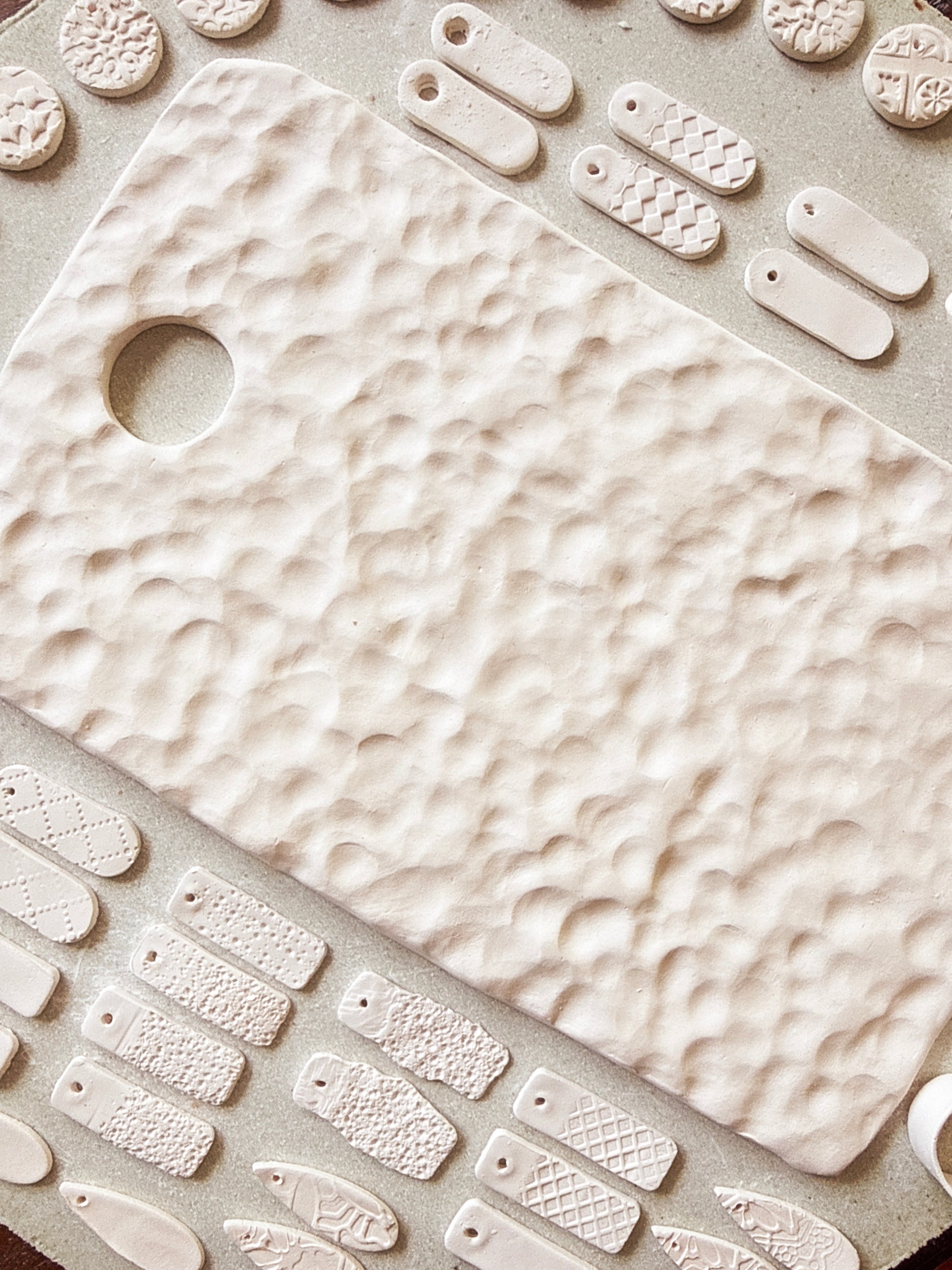 Close-up of a textured ceramic cutting board with various shapes and patterns.